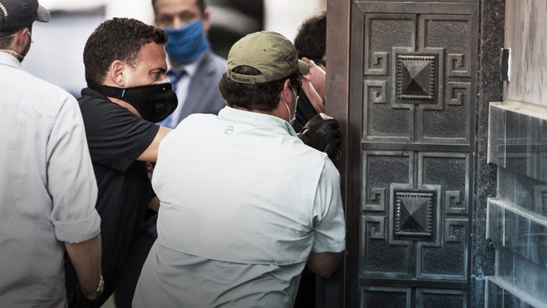 Federal officials and a locksmith pull on a door to make entry into the vacated Consulate General of China building Friday, July 24, 2020, in Houston.