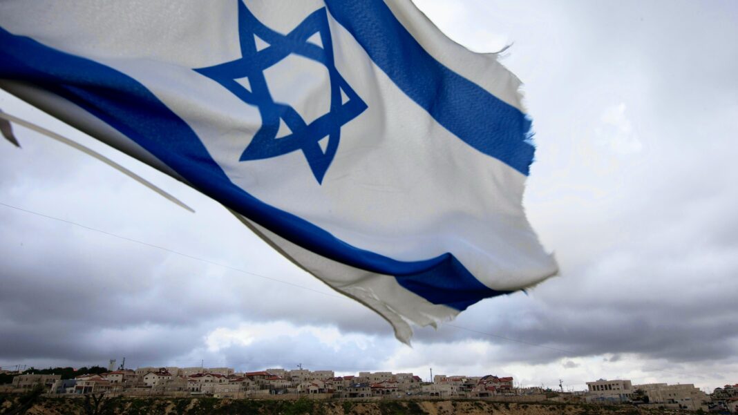 an israeli flag flies on a hill near the west bank jewish settlement of elazar, near bethlehem