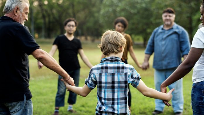 group of people holding hand together in the park