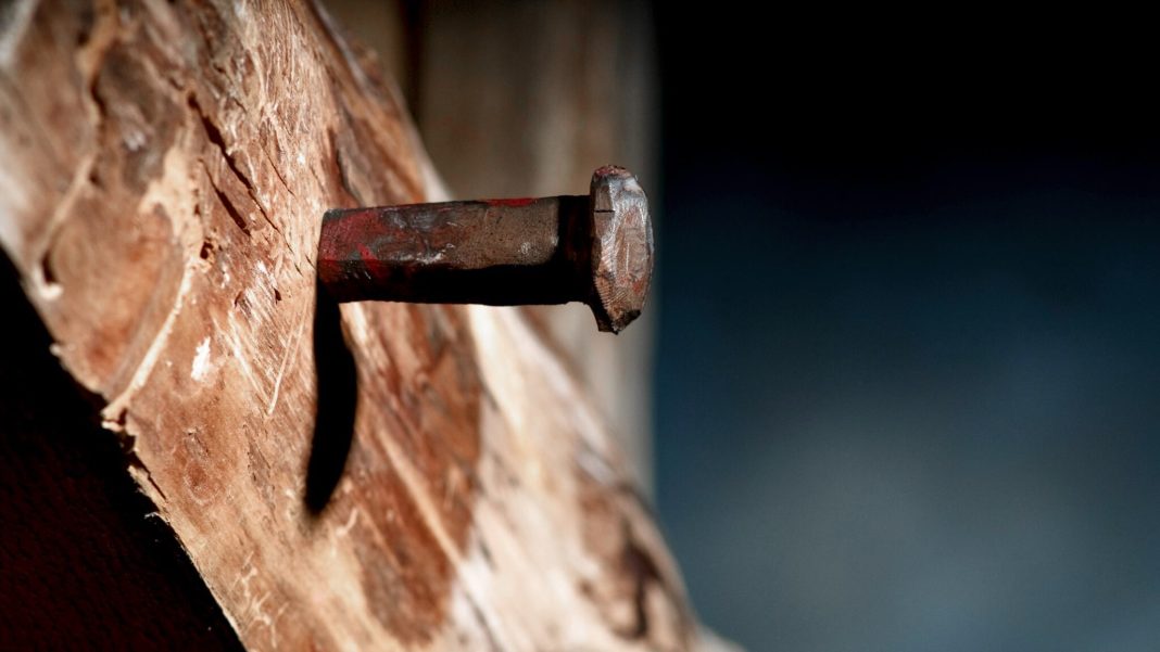 spike driven into wooden cross