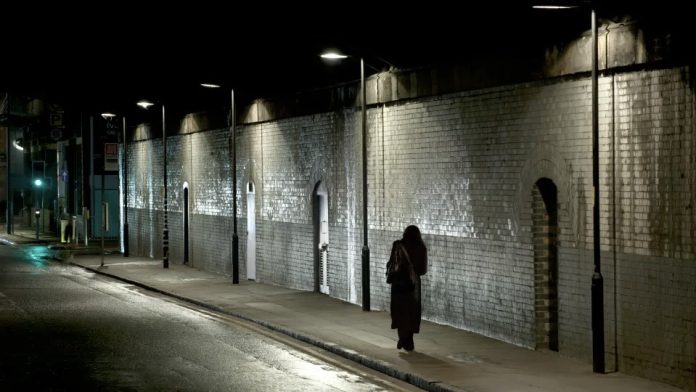 woman walks alone beneath dark 276213158