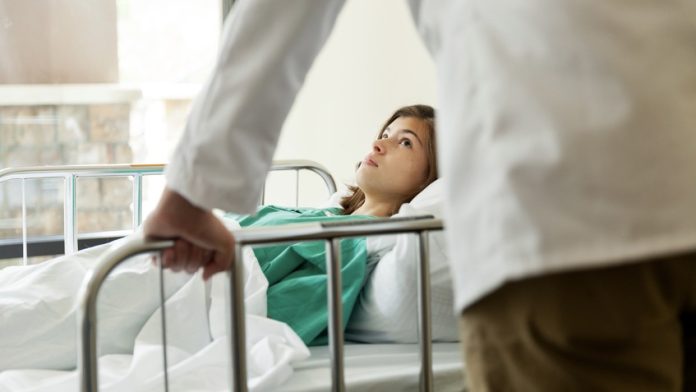 young serious teenager in a hospital bed