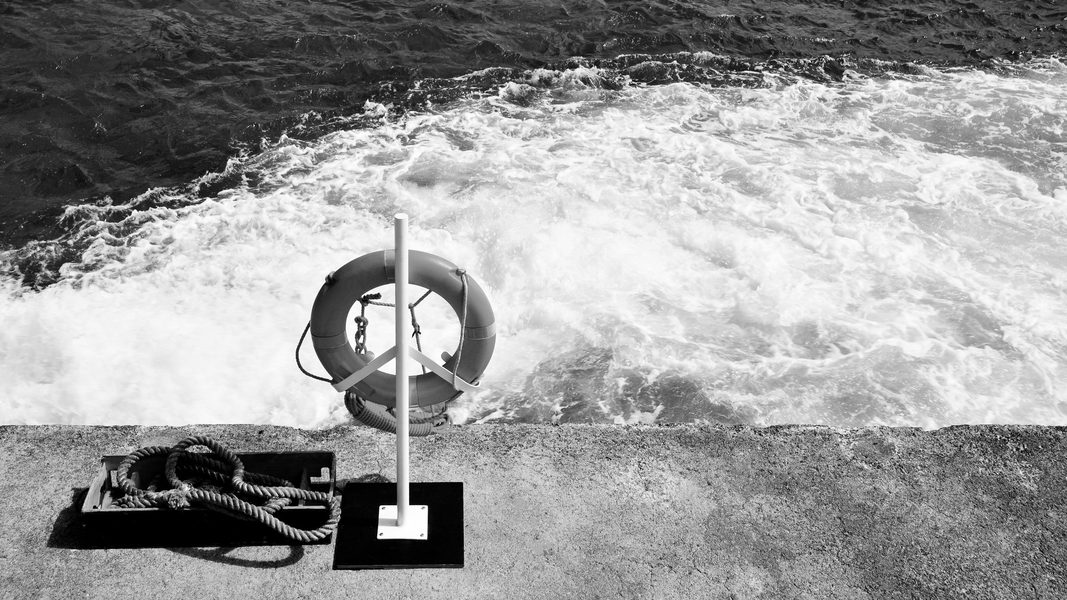 orange life buoy ring hanging on a pillar