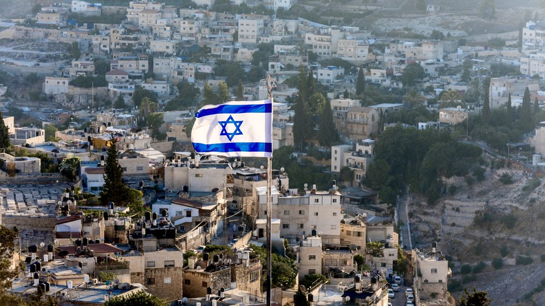israeli national flag waving on the top of mount of olive with background of residential houses in jerusalem israel stockpack adobe stock scaled 2